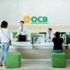 Khách hàng giao dịch tại ngân hàng OCB. (Ảnh: PV/Vietnam+)