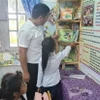 Học sinh điểm trường Ia Jip, trường Tiểu học Trần Quốc Tuấn, xã Chư Drăng, huyện Krông Pa, tỉnh Gia Lai chọn sách, truyện tại Tủ sách Đinh Hữu Dư. (Ảnh: Hồng Điệp/TTXVN)