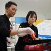 Đầu bếp Christine Ha (phải) và đầu bếp Tuyết Phạm - á quân MasterChef Việt Nam 2015 truyền cảm hứng nấu ăn cho các học viên. (Ảnh: Trần Lê Lâm/TTXVN)