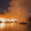 Cảnh sát Phòng cháy chữa cháy sử dụng ca nô chuyên dụng để phun nước vào đám cháy. (Ảnh: TTXVN)