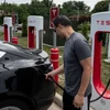 Người dân sạc điện cho ôtô tại một trạm sạc của Tesla ở Arlington, Virginia, Mỹ. (Ảnh: AFP/TTXVN)