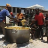 Trẻ em nhận bữa ăn từ thiện tại Howlwadag, phía Nam thủ đô Mogadishu, Somalia. (Ảnh: AFP/TTXVN)