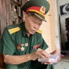 Đại tá Lê Kim Thơ (Cục Tham mưu Công binh, Bộ Tư lệnh Đoàn 559) lưu giữ cẩn thận cuốn sổ ghi chép ghi lại thời hoa lửa chiến đấu trên tuyến đường Trường Sơn huyền thoại. (Ảnh: Nguyên Linh/TTXVN)