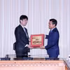 Phó Chủ tịch Ủy ban Nhân dân Thành phố Hồ Chí Minh Bùi Xuân Cường (phải) trao quà đối ngoại cho Thứ trưởng Bộ Ngoại giao Nhật Bản Komura Masahiro. (Ảnh: Xuân Khu/TTXVN)