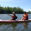Du khách quốc tế chèo thuyền Kayak trên sông Cửa Cạn, thành phố Phú Quốc (Kiên Giang). (Ảnh: Lê Huy Hải/TTXVN)