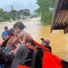Lực lượng cứu hộ sơ tán em nhỏ khỏi vùng ngập lụt tại thị trấn Catarman, Philippines, ngày 21/11/2023. (Ảnh: AFP/TTXVN)