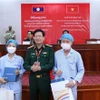 Thiếu tướng, Phó Giáo sư, Tiến sỹ Nguyễn Xuân Kiên, Giám đốc Bệnh viện 103 Việt Nam, tặng quà cho 2 bệnh nhân người Lào được ghép thận thành công. (Ảnh: Phạm Kiên-Bá Thành/TTXVN)