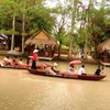 Du khách trải nghiệm chèo thuyền trên sông ở Làng du lịch Mỹ Khánh. (Ảnh: Thu Hiền/TTXVN)
