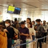 Hành khách xếp hàng làm thủ tục soi chiếu kiểm tra an ninh tại sân bay Tân Sơn Nhất. (Ảnh: Quang Châu/TTXVN)