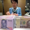 Nhân viên ngân hàng kiểm đếm đồng Baht tại Bangkok, Thái Lan. (Ảnh: AFP/TTXVN)