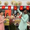 Ban tổ chức thích thú giới thiệu về nón lá Việt Nam. (Ảnh: Đỗ Vân/TTXVN)
