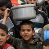 Trẻ em Palestine nhận thực phẩm cứu trợ tại thành phố Rafah, Dải Gaza ngày 19/11/2023. (Nguồn: THX/TTXVN)