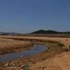 Lòng hồ Đankia ở phía thượng nguồn bị thu hẹp thành một dòng nước nhỏ trong mùa khô năm 2021. (Ảnh: Nguyễn Dũng/TTXVN) 