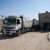 Xe tải chở hàng viện trợ qua cửa khẩu Kerem Shalom vào Dải Gaza ngày 15/4/2024. (Ảnh: AFP/TTXVN)