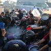 Người dân xếp hàng chờ được phát thức ăn cứu trợ tại Rafah, Dải Gaza, ngày 14/3/2024. (Ảnh: THX/TTXVN)