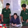 Bà Trần Hồng Diễm, chủ tàu cá CM 92114 TS, ký biên bản triển khai Quyết định của Chủ tịch Ủy ban Nhân dân tỉnh về việc xử phạt vi phạm hành chính đối với tàu vi phạm. (Ảnh: TTXVN phát)