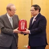 Thủ tướng Phạm Minh Chính tặng quà cho cựu Thủ tướng Nhật Bản Yasuo Fukuda. (Ảnh: Dương Giang/TTXVN)