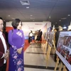 Đại biểu tham quan trưng bày triển lãm 42 tác phẩm ảnh xuất sắc. (Ảnh: Minh Quyết/TTXVN)