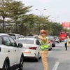 Lực lượng Cảnh sát giao thông phân luồng phương tiện đi lại tại nút giao cao tốc Pháp Vân. (Ảnh: Hoài Nam/Vietnam+)