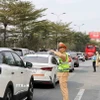 Lực lượng Cảnh sát giao thông phân luồng phương tiện đi lại tại nút giao cao tốc Pháp Vân. (Ảnh: Hoài Nam/Vietnam+)