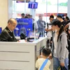 Nhân viên an ninh hàng không kiểm tra giấy tờ hành khách làm thủ tục chuyến bay. (Ảnh: PV/Vietnam+)