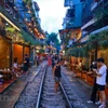 Nhiều du khách vẫn đến chụp ảnh tại tụ điểm tụ điểm phố càphê đường tàu. (Ảnh: Minh Sơn/Vietnam+)