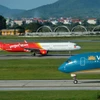 Máy bay của hai hãng hàng không Vietnam Airlines và Vietjet đang chuẩn bị cất, hạ cánh tại một sân bay. (Ảnh: PV/Vietnam+)