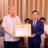 Thường trực Ban Bí thư, Chủ nhiệm Ủy ban Kiểm tra Trung ương Trần Cẩm Tú trao Huy hiệu 50 năm tuổi Đảng tặng ông Đinh Thế Huynh. (Ảnh: Phạm Kiên/TTXVN)