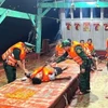 Lực lượng quân y Đồn Biên phòng Sông Đốc (Cà Mau) tích cực hỗ trợ chăm sóc sức khỏe cho các thuyền viên ngay sau khi được cứu vớt thành công. (Ảnh TTXVN phát)