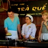 Du khách quốc tế trải nghiệm làm bánh xèo ở Hội An. (Ảnh: Mai Mai/Vietnam+)