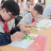Học sinh vẽ tranh hưởng ứng cuộc thi. (Ảnh: Phạm Mai/Vietnam+)