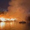 Cảnh sát Phòng cháy chữa cháy sử dụng canô chuyên dụng phun nước vào đám cháy. (Ảnh: TTXVN)