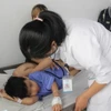 Bác sỹ Bệnh viện Đa khoa Tâm Trí Nha Trang kiểm tra sức khỏe cho bệnh nhi trong vụ ngộ độc thực phẩm. (Ảnh: Phan Sáu/TTXVN)