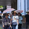 Du khách tham quan Hà Nội trong thời tiết nắng nóng. (Ảnh: Tuấn Anh/TTXVN)