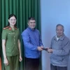 Cụ Phạm Xuân Tuệ trả lại tài sản cho người đánh rơi tại Công an phường 2. (Ảnh TTXVN phát)