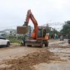 Thành phố Hà Giang huy động các lực lượng và phương tiện dọn dẹp tuyến đường bị ngập sâu. (Ảnh: TTXVN phát)