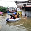 Cán bộ, chiến sỹ Công an tỉnh Hà Giang hỗ trợ di chuyển người và tài sản bị ngập sâu trong nước. (Ảnh: Nguyễn Lân/TTXVN phát)