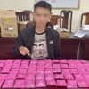 Đối tượng Trần Thượng Nhật cùng tang vật. (Ảnh TTXVN phát)