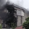 Hình ảnh anh Bằng cõng 2 cô gái leo tường thoát khỏi vụ cháy. (Ảnh cắt từ clip).