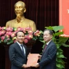 Ủy viên Trung ương Đảng, Bí thư Thành ủy Đà Nẵng Nguyễn Văn Quảng (phải) trao Quyết định của Ban Bí thư Trung ương Đảng chuẩn y ông Nguyễn Đình Vĩnh giữ chức Phó Bí thư Thành ủy Đà Nẵng. (Ảnh: Quốc Dũng/TTXVN)