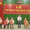 Trao huy hiệu Đảng cho các đảng viên. (Ảnh: Huỳnh Phúc Hậu/TTXVN)