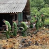 Công an huyện Na Hang (Tuyên Quang) giúp đỡ người dân thôn Khau Phiêng khắc phục hậu quả do mưa lũ. (Ảnh: Nam Sương/TTXVN)