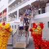 Du khách hào hứng với màn múa lân chào đón khi vừa xuống tàu. (Ảnh: Trần Lê Lâm/TTXVN)