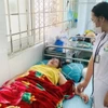 Bác sỹ của một trung tâm Y tế huyện thăm khám cho các bệnh nhân bị ngộ độc sau khi đi ăn đám cưới. (Ảnh: TTXVN phát)