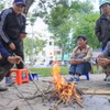 Dù ban ngày có nắng, nhưng nền nhiệt giảm sâu khiến nhiều người dân phải đốt lửa sưởi ấm. (Ảnh: Hoàng Hiếu/TTXVN)