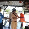 Lực lượng chức năng kiểm tra điều kiện hoạt động của phương tiện đò ngang hoạt động trên kênh xáng Xà No, tỉnh Hậu Giang. (Ảnh: Nguyễn Hằng/TTXVN)
