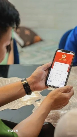 Tổ chuyển đổi số cộng đồng hướng dẫn người dân sử dụng ứng dụng định danh công dân trên môi trường kỹ thuật số (VNeID) có giá trị sử dụng thay thế các giấy tờ truyền thống. (Ảnh: Hoàng Hiếu/TTXVN)