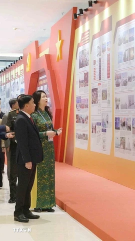 Thường trực Ban Bí thư Trần Cẩm Tú tham quan khu trưng bày ảnh “Dưới cờ Đảng - đất nước tiến vào kỷ nguyên mới” do TTXVN thực hiện. (Ảnh: Phương Hoa/TTXVN)