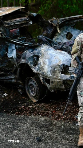 Binh sỹ Liban gác tại hiện trường vụ không kích của Israel nhằm vào chiếc xe chở thành viên lực lượng Hezbollah ở Sidon, miền Nam Liban. (Ảnh: THX/TTXVN)