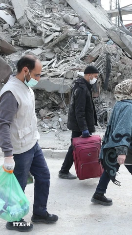 Người dân đi qua đống đổ nát của những tòa nhà bị phá hủy tại Tehran, Iran. (Ảnh: THX/TTXVN)